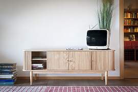 TV-Möbel aus hellem Holz mit Schiebetüren,